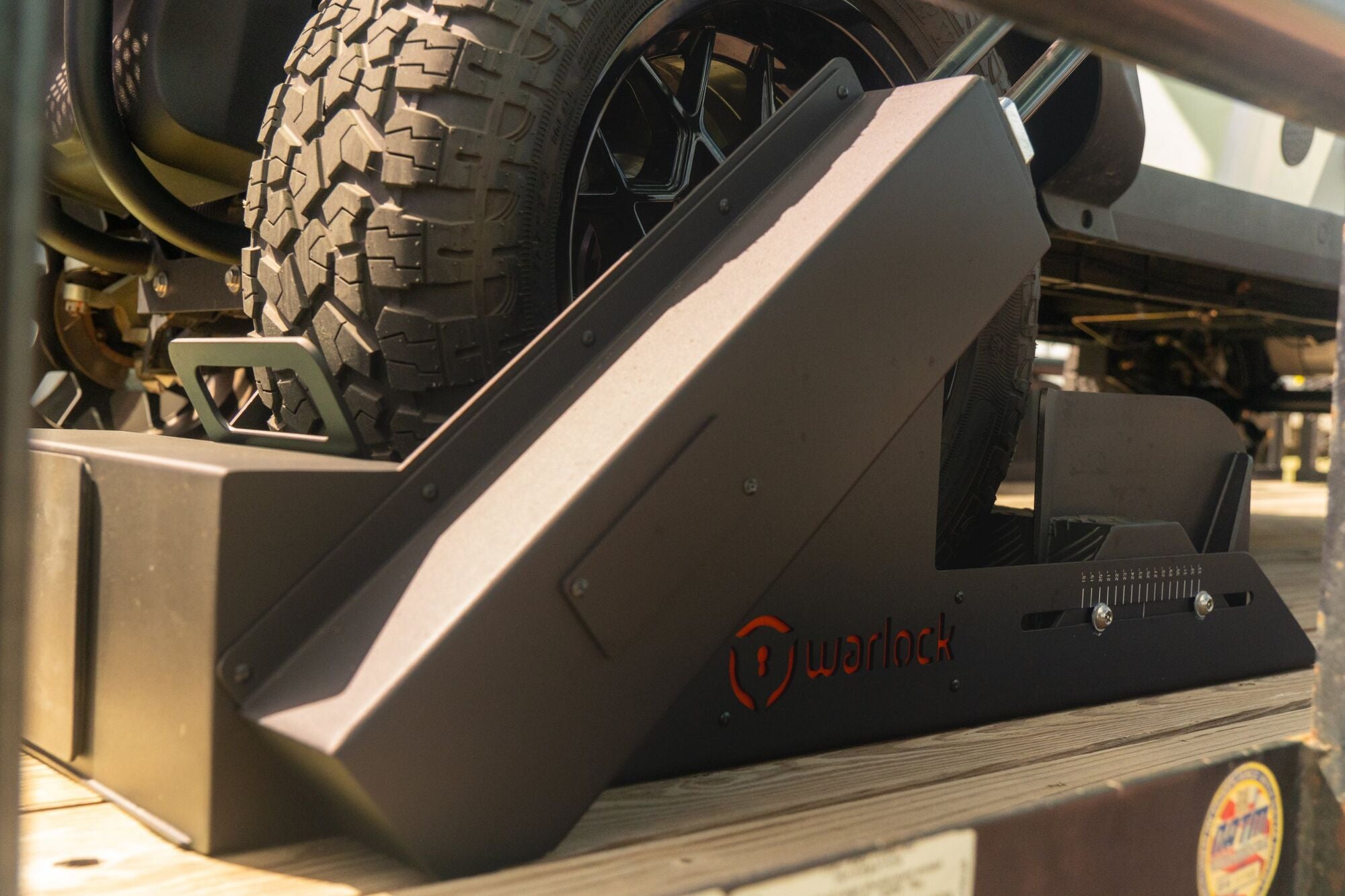 Close-up of the Warlock arm clamped over an all-terrain tire on a trailer